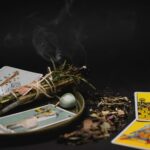 Variedade de incensos naturais e cristais dispostos ao lado de um baralho de tarot em um altar místico.