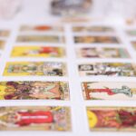 Mãos segurando três cartas de tarot sobre um fundo romântico com velas e cristais