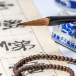 Tabela do Horóscopo Chinês com estátua dourada do Cavalo de Fogo rodeada por moedas chinesas da sorte e cristais.